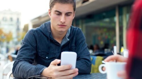 Young man checking phone while waiting for a message reply