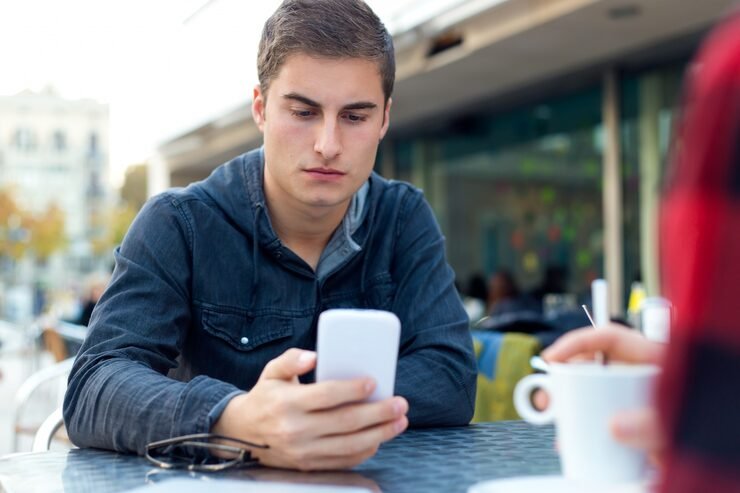 Young man checking phone while waiting for a message reply